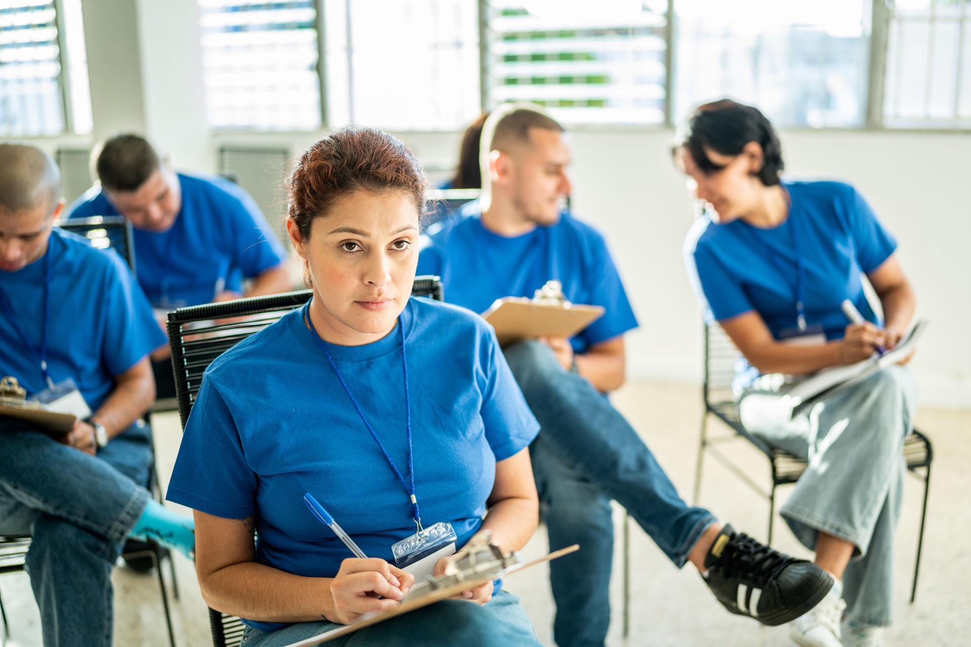 Mid adult woman taking notes on a clipboard during meeting at community center